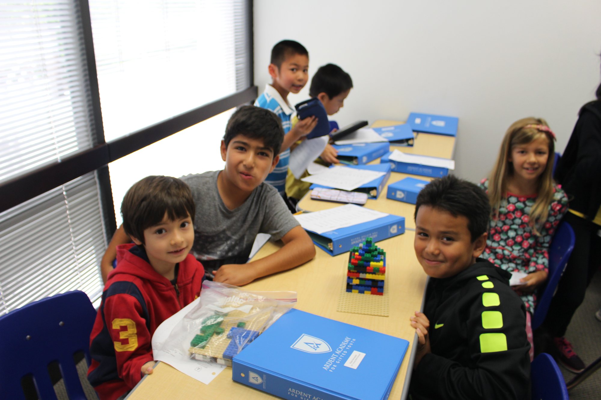 Students work at tables with Ardent binders and building blocks.