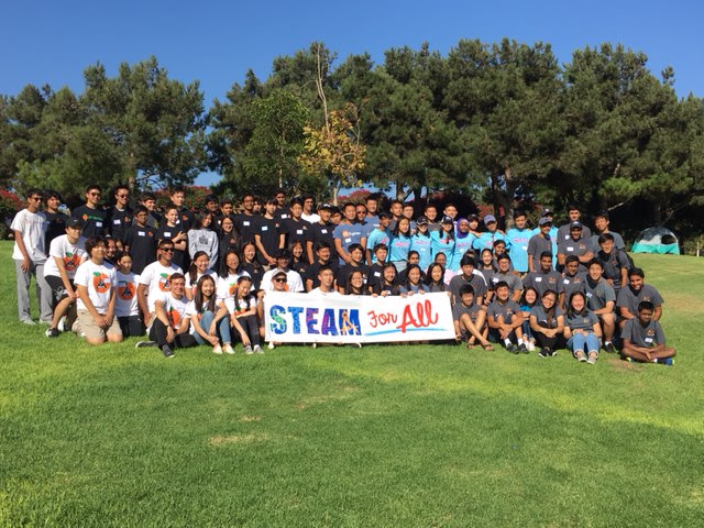 STEAM for All volunteers gathered outdoors behind the STEAM for All banner.